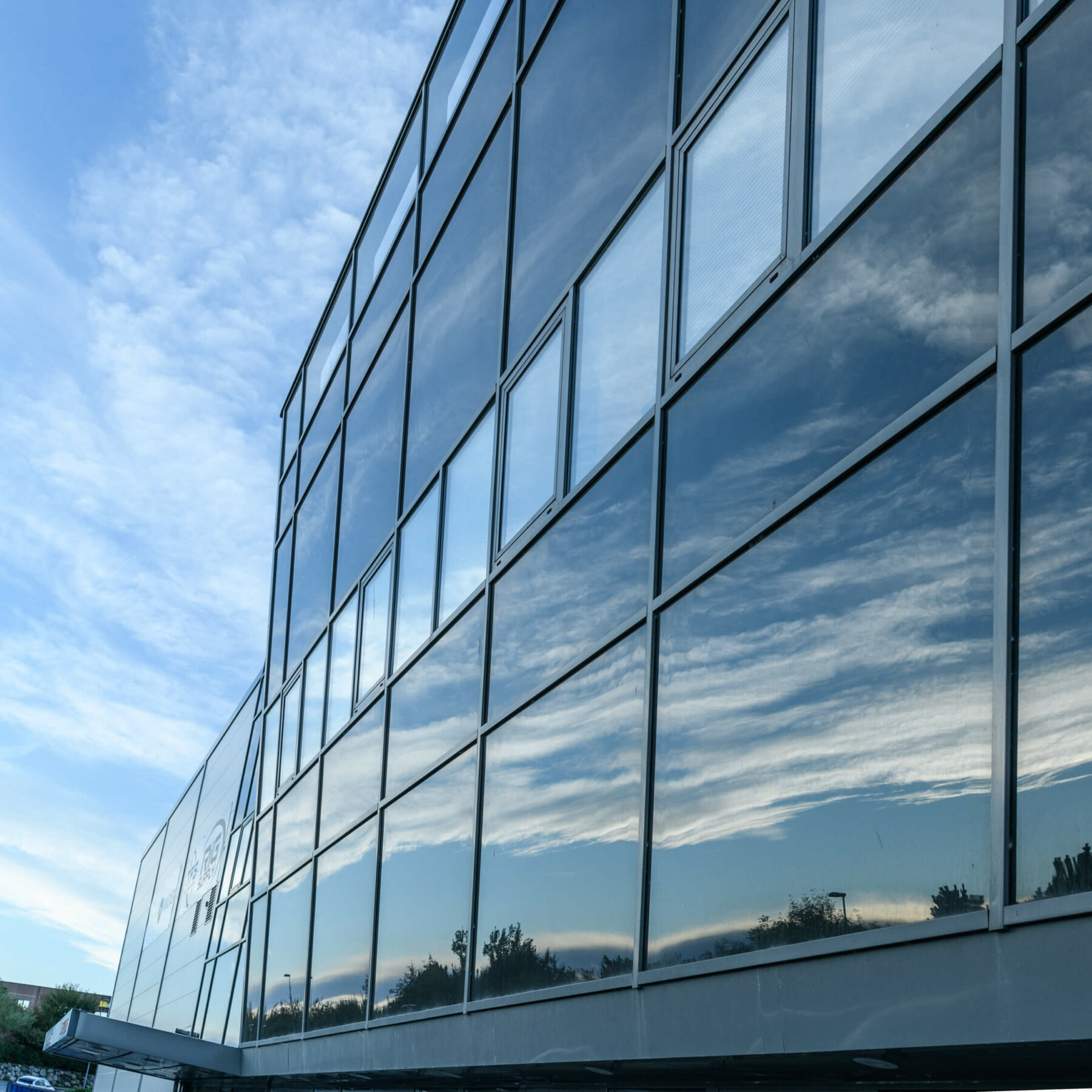 Glassfasade med speiling av himmel